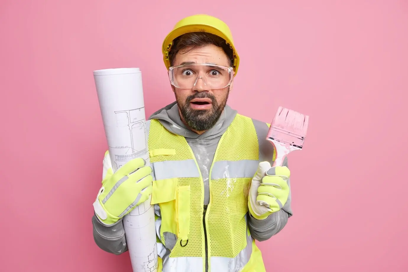 Mann, der an Hausrenovierungsarbeiten beteiligt ist, bietet einen professionellen Reparaturservice an, hält einen Malerpinsel, erstellt einen architektonischen Bauplan und trägt Schutzkleidung.